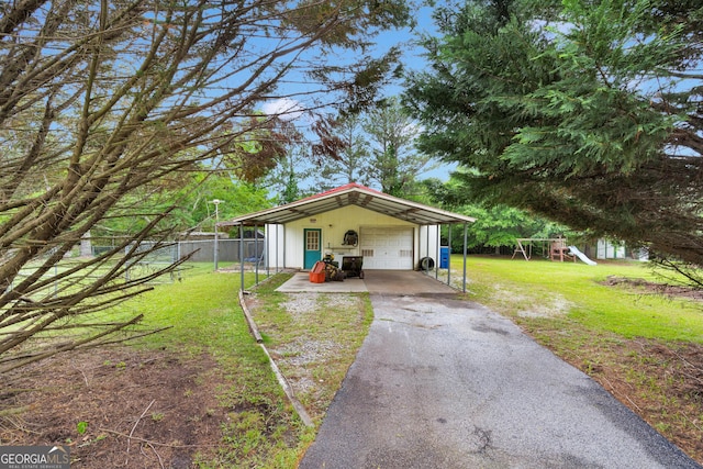 95 Stephens Dr, Covington, GA 30016 - view of front facade with a detached garage, a playground, an outdoor structure, and asphalt driveway