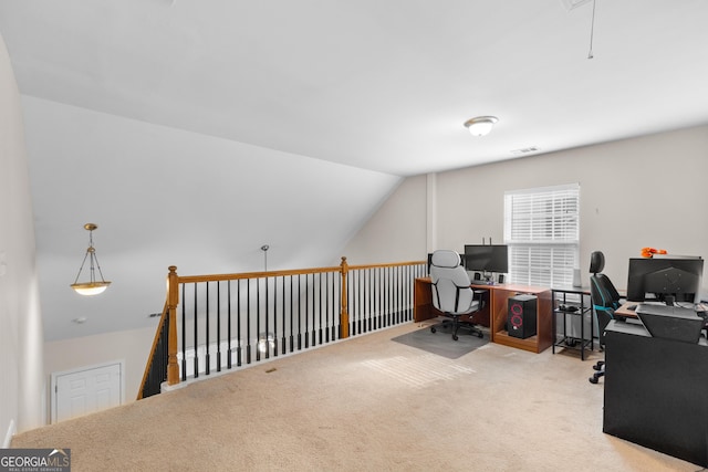 home office featuring carpet floors, lofted ceiling, and attic access
