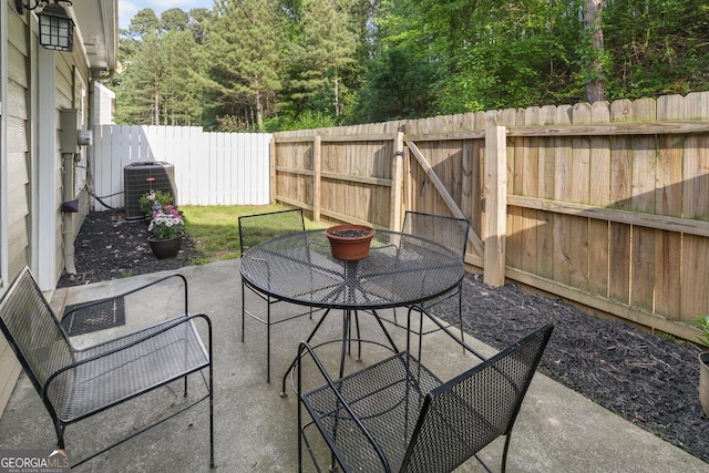 view of patio / terrace with outdoor dining area, central AC, and a fenced backyard