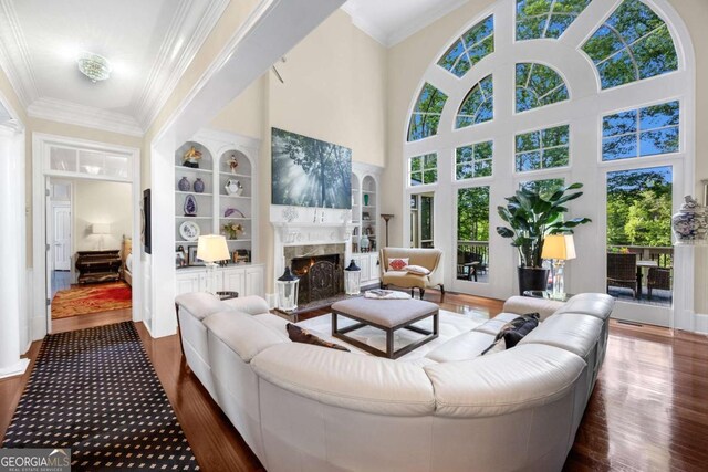 3182 Deepwater Dr, Gainesville, GA 30506 - living area featuring dark wood-style flooring, plenty of natural light, a fireplace, ornamental molding, and a high ceiling