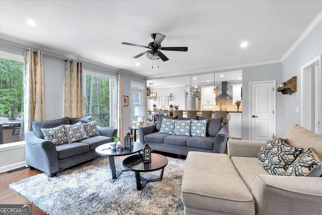 living room with a ceiling fan, crown molding, wood finished floors, and recessed lighting