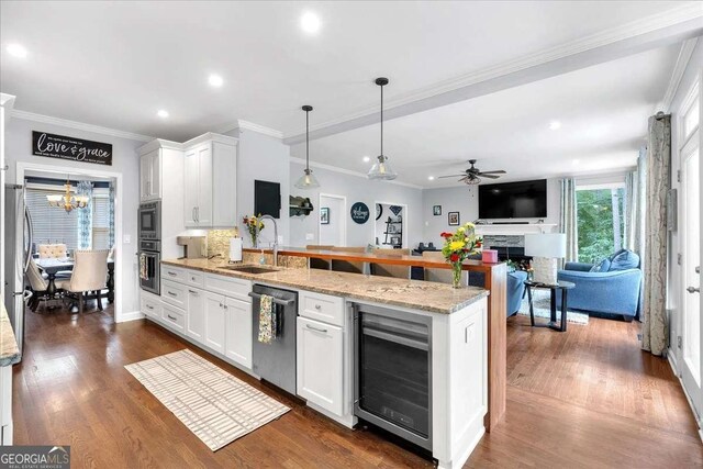 kitchen featuring beverage cooler, dishwasher, wall oven, a peninsula, and a sink