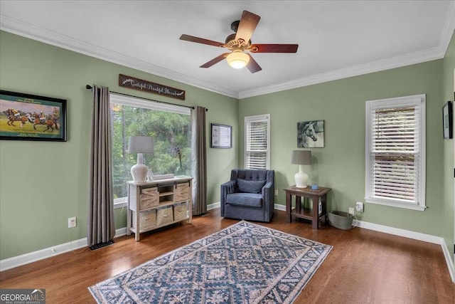 living area with ceiling fan, wood finished floors, crown molding, and baseboards