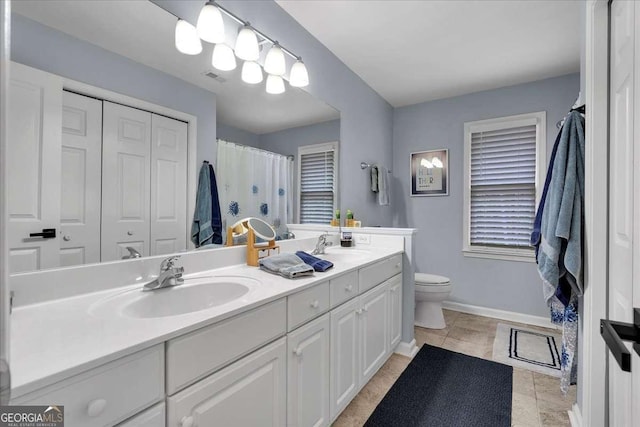 bathroom with toilet, double vanity, baseboards, a shower with shower curtain, and tile patterned flooring