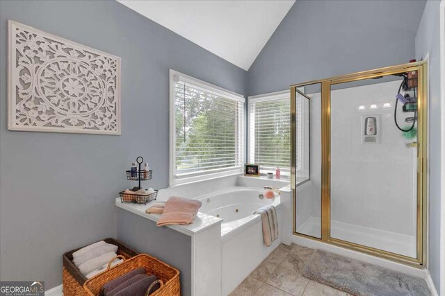 bathroom featuring lofted ceiling, a shower stall, a whirlpool tub, and tile patterned flooring