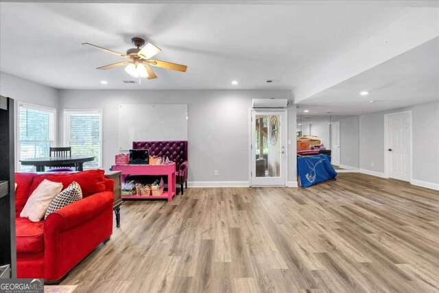 living area featuring wood finished floors, a ceiling fan, recessed lighting, and baseboards