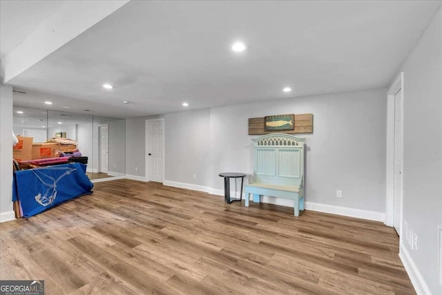 basement with recessed lighting, wood finished floors, and baseboards