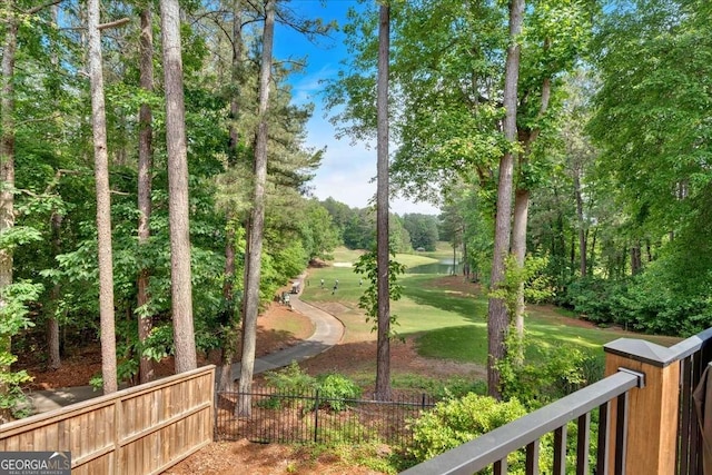view of property's community featuring fence and view of golf course
