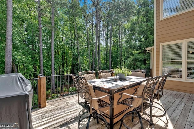deck with outdoor dining space and area for grilling
