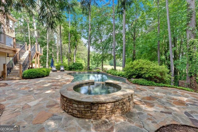 view of swimming pool featuring stairway, a patio area, and a pool with connected hot tub