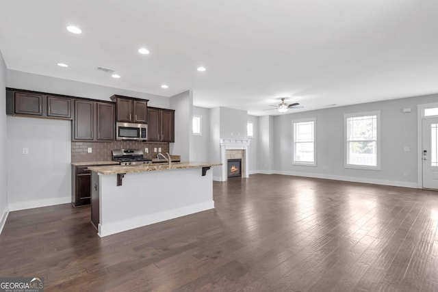 2342 Terrace View Cir SW, Atlanta, GA 30315 - kitchen with stainless steel appliances, ceiling fan, a breakfast bar, baseboards, and open floor plan