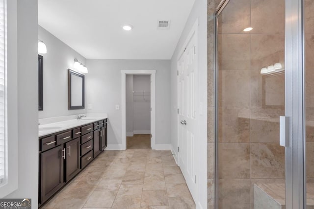 2342 Terrace View Cir SW, Atlanta, GA 30315 - bathroom featuring a stall shower, double vanity, a walk in closet, and baseboards