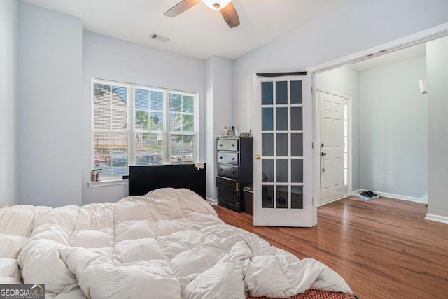 bedroom with wood finished floors, baseboards, lofted ceiling, and a ceiling fan