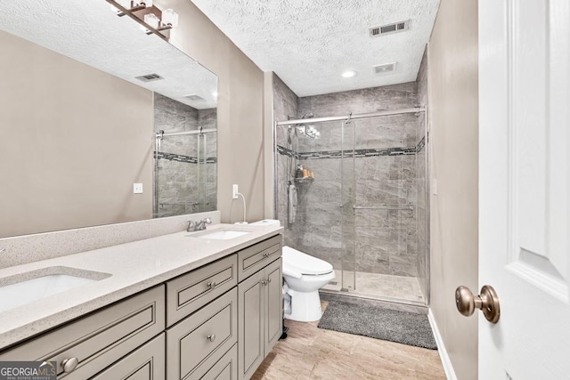 1500 Highland Farm Dr, Suwanee, GA 30024 - bathroom featuring a stall shower, a textured ceiling, double vanity, toilet, and baseboards