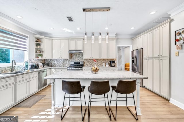 1500 Highland Farm Dr, Suwanee, GA 30024 - kitchen with stainless steel appliances, a sink, a breakfast bar, ornamental molding, and a kitchen island