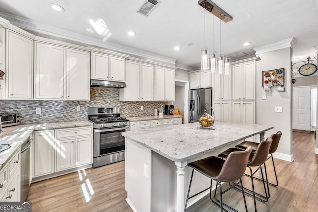 1500 Highland Farm Dr, Suwanee, GA 30024 - kitchen with appliances with stainless steel finishes, crown molding, a kitchen island, backsplash, and light stone counters