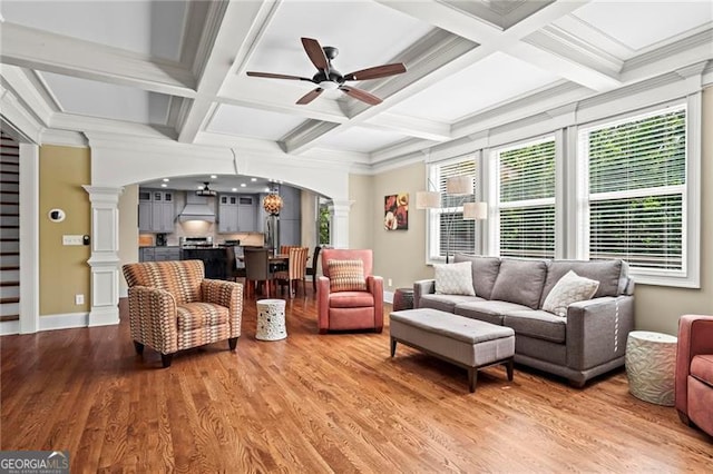 7493 Elderberry Dr, Douglasville, GA 30135 - living room with arched walkways, ornate columns, ceiling fan, light wood-style flooring, and coffered ceiling