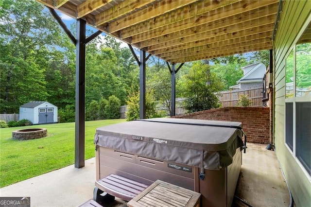 7493 Elderberry Dr, Douglasville, GA 30135 - view of patio featuring a hot tub, a fire pit, a storage unit, and an outdoor structure