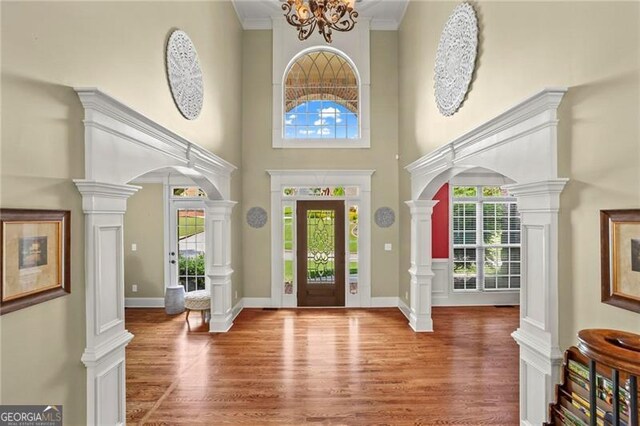 7493 Elderberry Dr, Douglasville, GA 30135 - entryway with wood finished floors, arched walkways, a high ceiling, ornamental molding, and baseboards