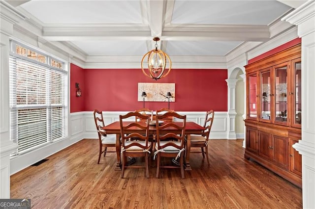 7493 Elderberry Dr, Douglasville, GA 30135 - dining area with ornate columns, wood finished floors, coffered ceiling, a decorative wall, and crown molding