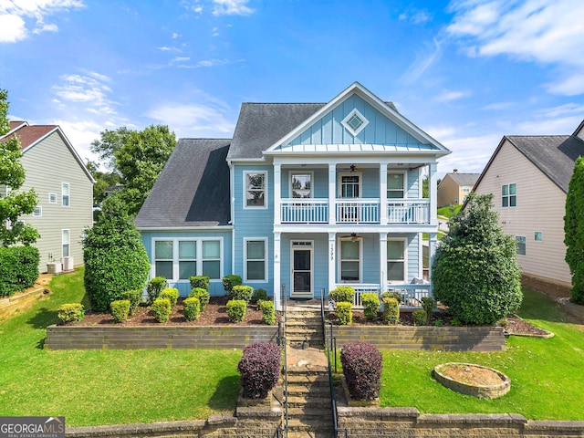1399 Kilchis Falls Way, Braselton, GA 30517 - view of front facade featuring a ceiling fan, a porch, board and batten siding, a balcony, and a front lawn