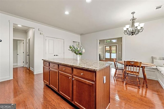 1399 Kilchis Falls Way, Braselton, GA 30517 - kitchen featuring wood finished floors, decorative light fixtures, a chandelier, a kitchen island, and ornamental molding
