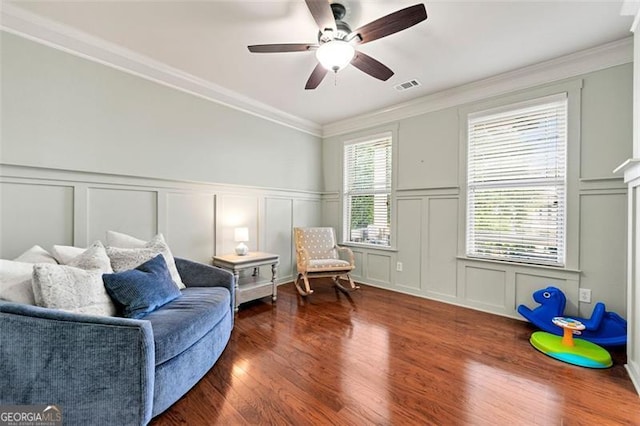 1399 Kilchis Falls Way, Braselton, GA 30517 - living area featuring a decorative wall, ceiling fan, wood finished floors, crown molding, and a wainscoted wall