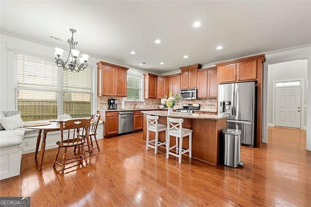 1399 Kilchis Falls Way, Braselton, GA 30517 - kitchen with stainless steel appliances, crown molding, decorative backsplash, a breakfast bar area, and a center island
