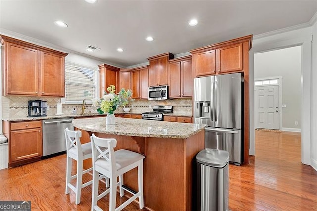 1399 Kilchis Falls Way, Braselton, GA 30517 - kitchen with appliances with stainless steel finishes, a center island, light wood-style flooring, decorative backsplash, and recessed lighting