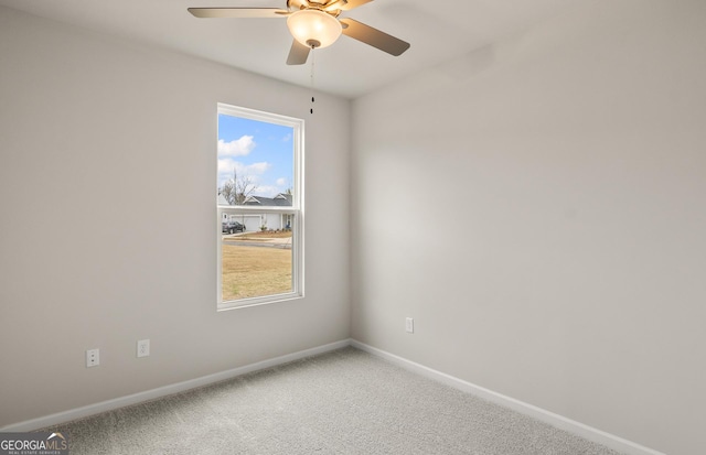 carpeted spare room with ceiling fan, baseboards, and plenty of natural light