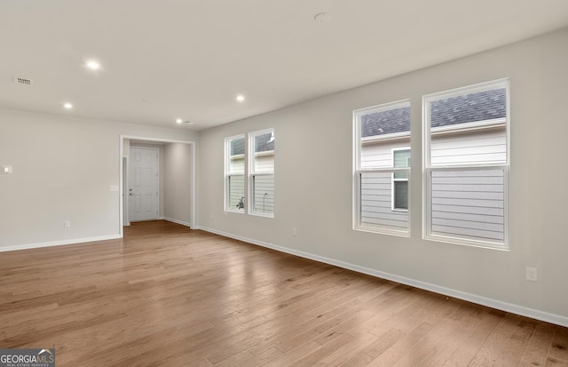 unfurnished room featuring baseboards, light wood finished floors, and recessed lighting