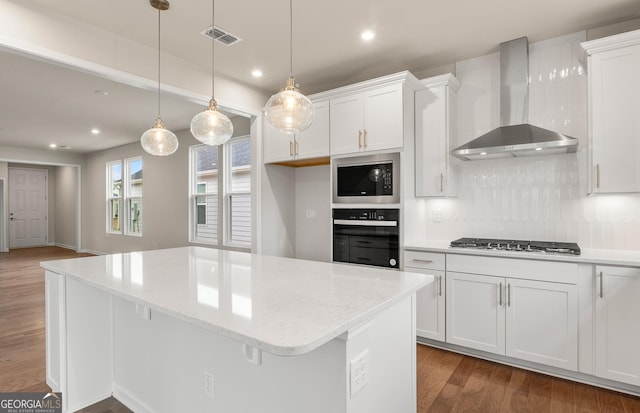 kitchen featuring wall chimney exhaust hood, stainless steel appliances, a kitchen island, recessed lighting, and dark wood-style flooring