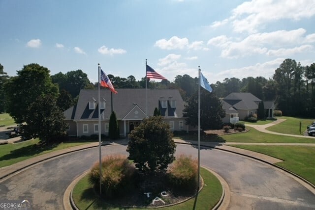 view of front facade with curved driveway and a front yard