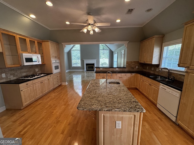 kitchen with white appliances, a sink, ceiling fan, decorative backsplash, and crown molding