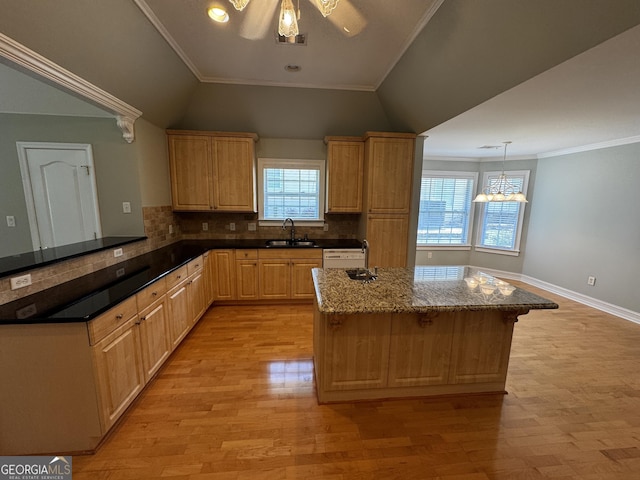 kitchen featuring a sink, light wood-style floors, vaulted ceiling, tasteful backsplash, and a chandelier