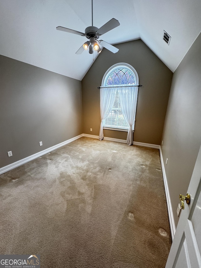 spare room with ceiling fan, carpet flooring, lofted ceiling, and baseboards