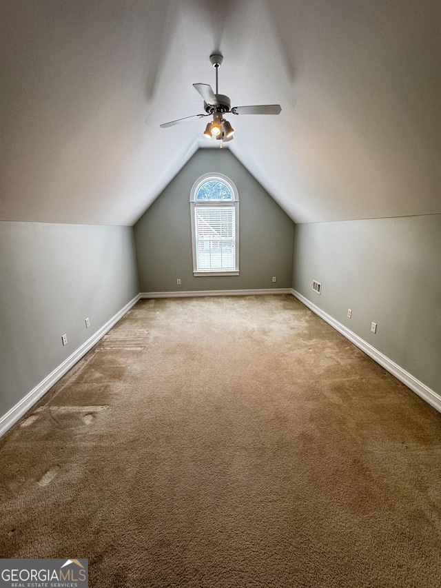 additional living space with carpet, a ceiling fan, baseboards, and lofted ceiling