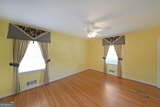 spare room featuring ceiling fan, wood finished floors, and baseboards