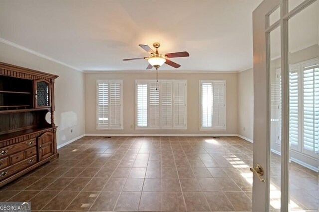 unfurnished living room with a ceiling fan, ornamental molding, baseboards, and tile patterned flooring