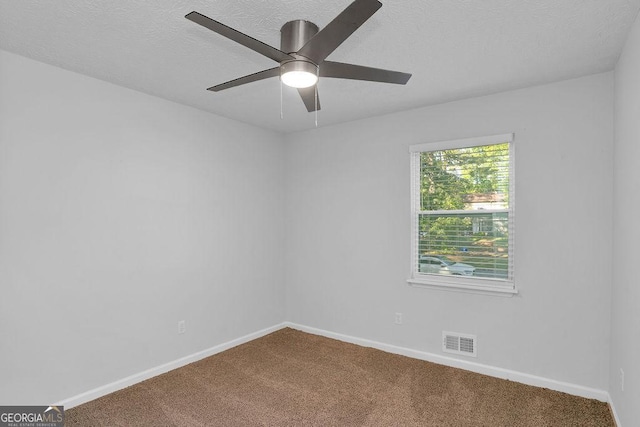 carpeted empty room featuring baseboards, a ceiling fan, and a textured ceiling
