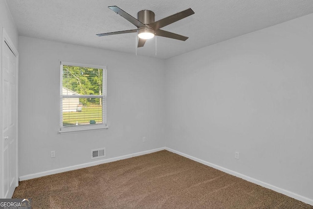 empty room with carpet floors, baseboards, a ceiling fan, and a textured ceiling