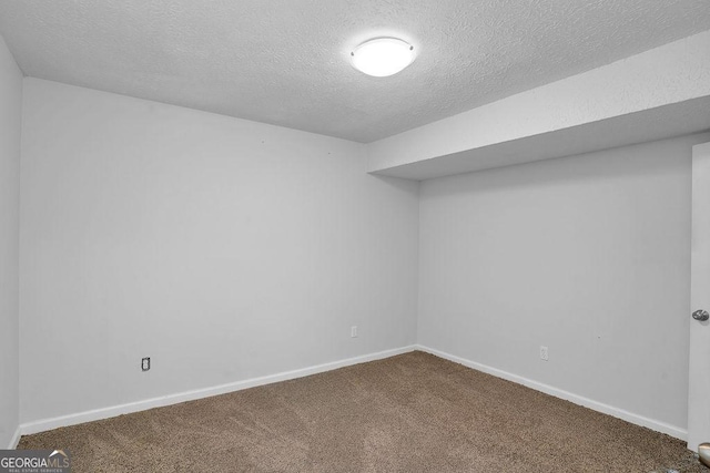 unfurnished room with carpet, a textured ceiling, and baseboards