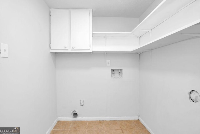 clothes washing area with hookup for a washing machine, cabinet space, baseboards, and hookup for an electric dryer