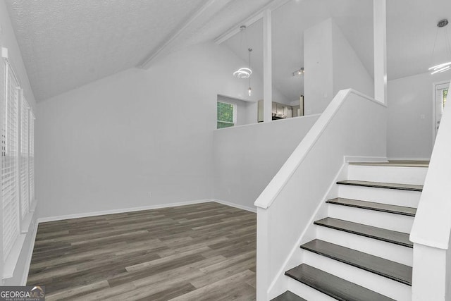 staircase with wood finished floors, a textured ceiling, baseboards, and high vaulted ceiling