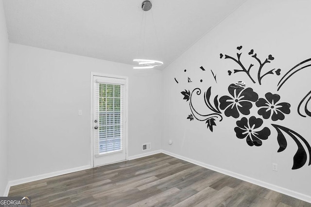 spare room featuring wood finished floors and baseboards