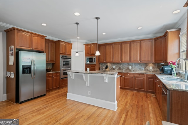 100 Braxton Way, Roswell, GA 30075 - kitchen featuring appliances with stainless steel finishes, a sink, brown cabinetry, a kitchen bar, and crown molding