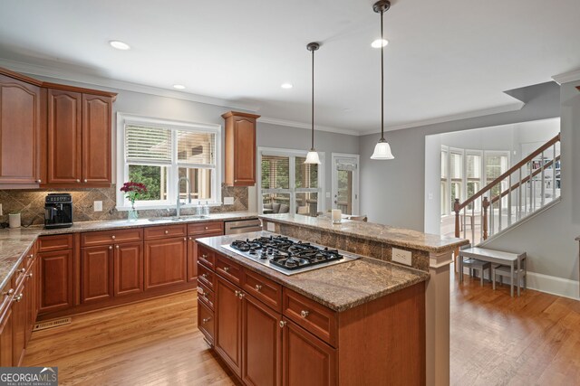 100 Braxton Way, Roswell, GA 30075 - kitchen with appliances with stainless steel finishes, a sink, light wood finished floors, tasteful backsplash, and ornamental molding