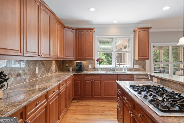 100 Braxton Way, Roswell, GA 30075 - kitchen featuring appliances with stainless steel finishes, light stone counters, crown molding, light wood-type flooring, and a sink