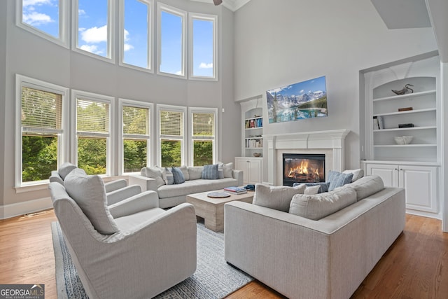 100 Braxton Way, Roswell, GA 30075 - living area with built in features, a high ceiling, healthy amount of natural light, and a glass covered fireplace
