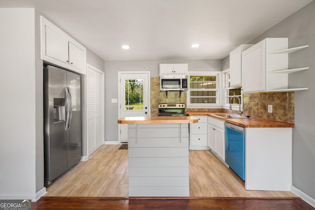 765 Shellnut Dr, Forest Park, GA 30297 - kitchen featuring appliances with stainless steel finishes, butcher block countertops, a sink, white cabinets, and decorative backsplash